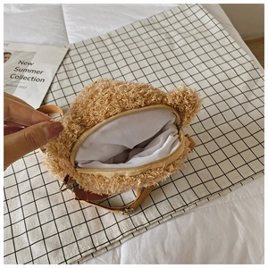 Detail of soft brown plush bag interior showing zipper closure and white fabric lining