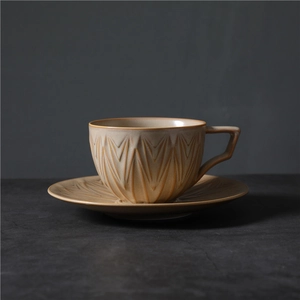 Tasse à café rétro en céramique beige avec motifs gravés et une poignée géométrique
