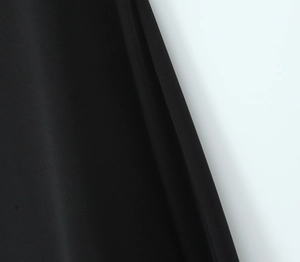 Detailed close-up of smooth black chiffon fabric with fine texture and draped edge