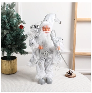 Close-up of silver and white Santa figurine with sequins, staff, and gift bag decoration