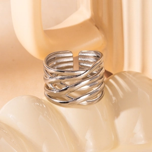 Detail of silver open ring featuring a braided metal texture on a soft beige background