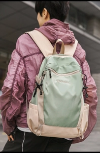 Close-up of mint green and beige water-resistant nylon backpack with side mesh pockets
