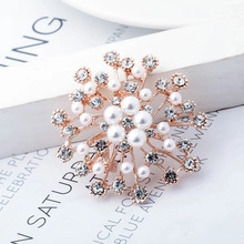 Macro detail of golden owl brooch featuring white pearls and sparkling crystal rhinestones