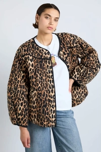 Detail of vintage leopard print quilted jacket with black trim and button closure