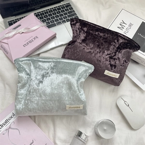 Detail of luxury velvet cosmetic bags in silver-blue and purple colors with premium packaging