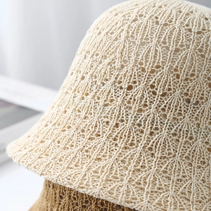 Close-up of wavy hollow knit texture on stylish crochet bucket hats in beige and brown