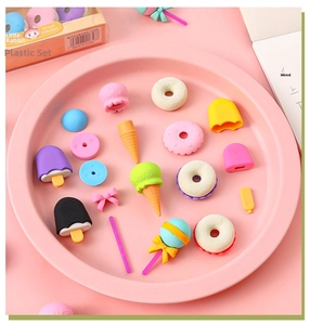 Flat lay of colorful dessert-shaped erasers including donuts and ice cream on pink background