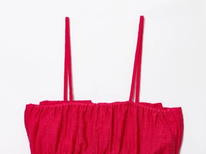 Détail du crop top en lin rose fuchsia montrant le tissu tissé et les coutures fines