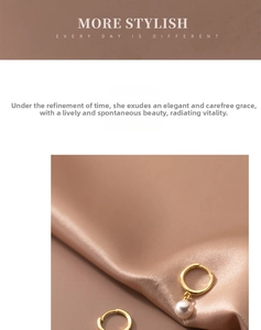 Detail of elegant gold hoop earrings with white pearls on a soft silk background