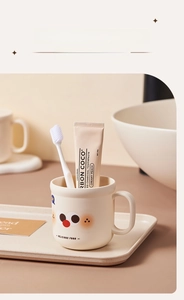 Détail d'un joli gobelet de brossage de dents en dessin animé de couleur crème