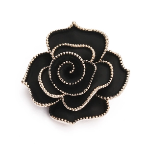 Detailed close-up of a vintage black rose brooch with elegant golden beaded edges