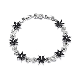 Detail of silver chain bracelet with black zircon floral charm and sparkling crystal link