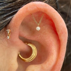 Close-up of S925 sterling silver chain earrings with a white pearl on a female model
