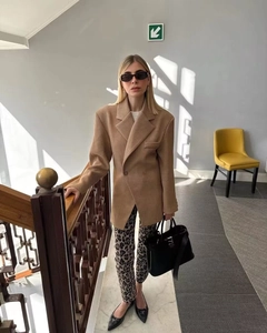 Photo street style d'une femme en blazer oversize en laine camel avec double boutonnage