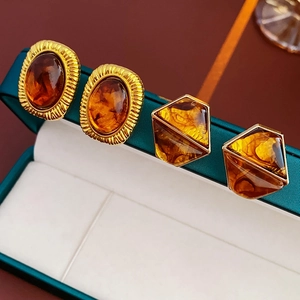 Detailed view of vintage amber resin earrings with textured gold geometric frames