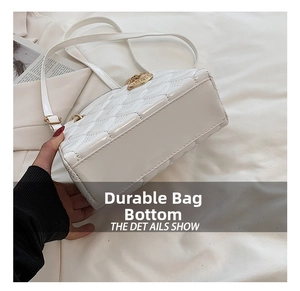 Detailed close-up view showing the wear-resistant base of a white quilted leather handbag