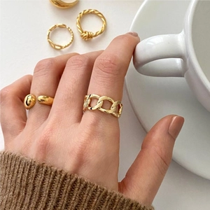 Detail of gold chain link ring and double ball open ring on model's hand