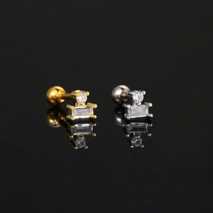 Detailed view of silver and gold zircon ear studs with screw ball backs on black mirror