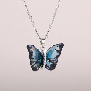 Detailed macro view of butterfly necklace pendant with blue wings and gold foil details
