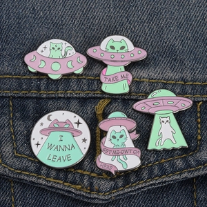 Détails de broches émaillées de chat extraterrestre et d'ovni sur une veste en jean