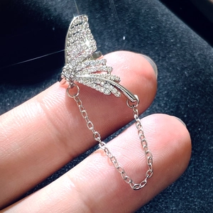 Macro shot of silver butterfly ear cuff featuring sparkling rhinestones and delicate chain link