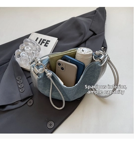 Detail view of the spacious inner compartment of the light blue canvas dumpling bag