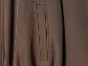 Détail de couture de qualité sur la poche et le tissu d'un blouson aviateur marron foncé