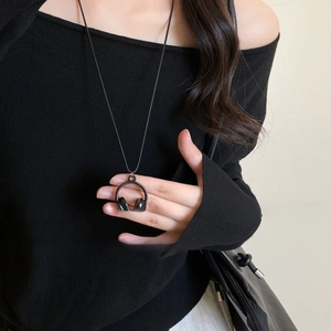 Gros plan du collier pendentif casque noir créatif sur le cou d'un mannequin
