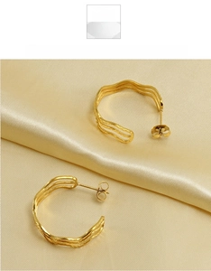 Macro shot of 18k gold plated stainless steel earrings with irregular wavy lines