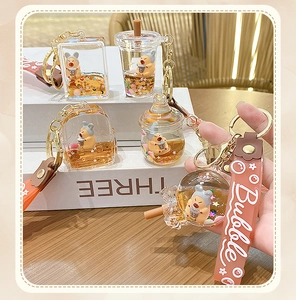 Detail of liquid oil quicksand bubble tea keychain with cute capybara and gold sequins