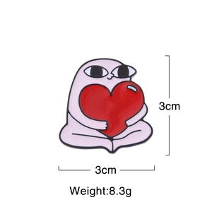 Detail view of 3cm cartoon enamel pin showing size, weight, and pink character with heart