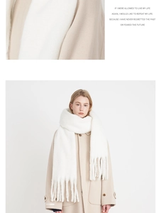 Detail of soft white cashmere-like scarf with thick tassels and fine fabric texture