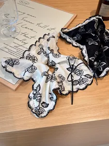 Detailed shot of floral satin scrunchies with white lace edges and pearl accents
