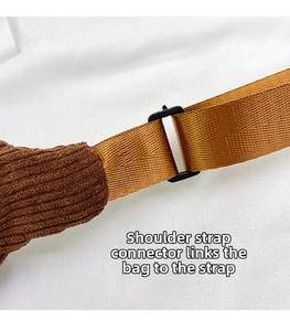 Detailed close-up of brown corduroy bag strap connection with black plastic buckle ring