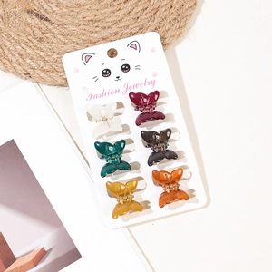 Detailed view of 6 colorful butterfly mini hair claws on a cat-themed display card