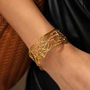 Macro detail of 18K gold plated wide hollow cuff bracelet with woven branch design