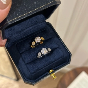 Macro view of gold and silver flower rings with white zircon in a velvet jewelry box
