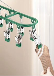 Close-up of olive green drying rack with stainless steel clips holding a striped sock