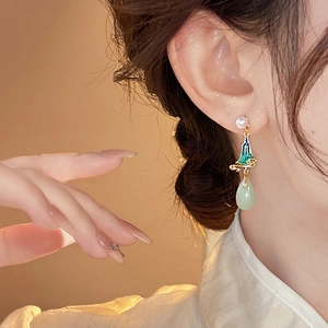 Macro detail of oriental enamel mountain earrings with pearl and green water drop pendant