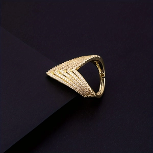 Macro view of luxury golden V-shape open ring with shimmering pavé diamond accents