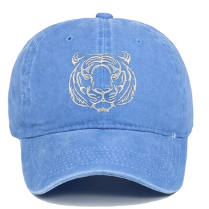 Close-up of silver tiger head embroidery on a washed navy cotton baseball cap