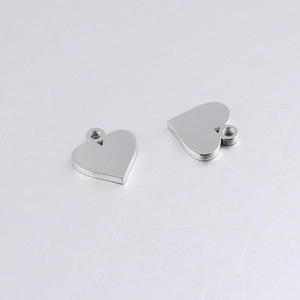 Macro shot of two polished heart pendants in stainless steel for DIY jewelry making