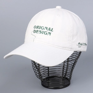 Close-up of white cotton baseball cap featuring green Original Design embroidery detail