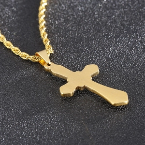 Close-up of golden stainless steel cross pendant with a twisted rope chain necklace
