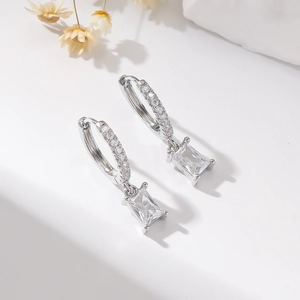 Detailed view of silver hoop earrings with rectangular zircon drop and pave stones