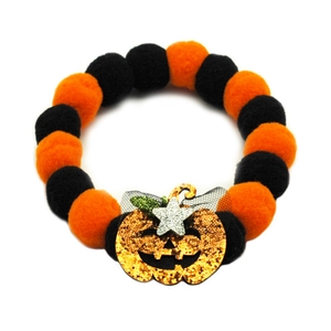 Detail of Halloween pet collar with orange and black plush balls and sequin pumpkin