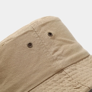 Detail of cotton bucket hat featuring metal eyelets and premium stitching textures
