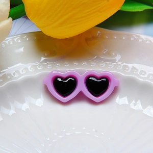 Purple heart sunglasses for dolls on a white ceramic plate with tulip petals decoration