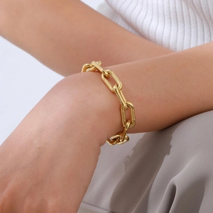 Detailed close-up of a 18K gold plated stainless steel Figaro bracelet on a wrist