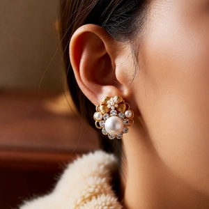 Close-up of vintage pearl flower earrings with rhinestones and gold petal details